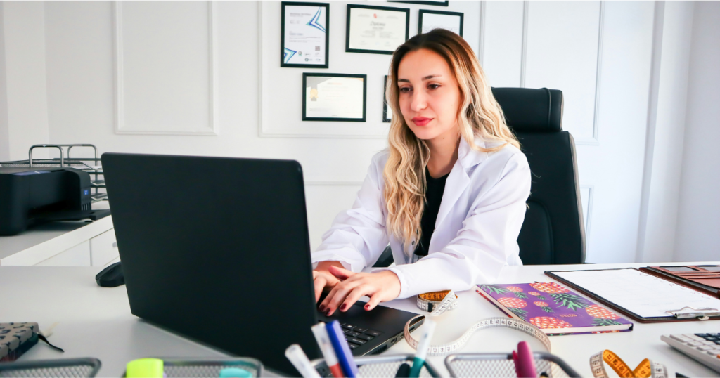 Nurse smiling while reviewing laptop for side hustle ideas